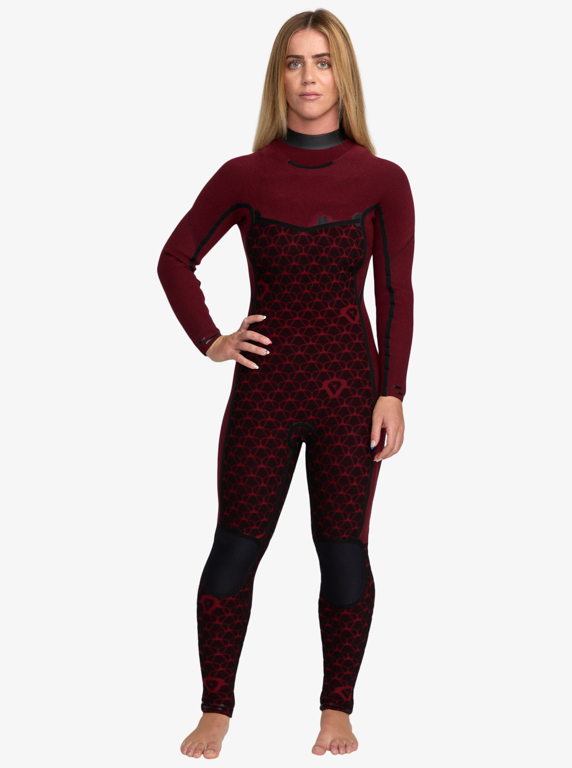 A woman stands confidently wearing a maroon and black patterned wetsuit with long sleeves. She has long hair and a calm expression, set against a white background.